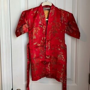 Child’s Beautiful red color. Measures 14’ across chest, 24’ shoulder to hem.